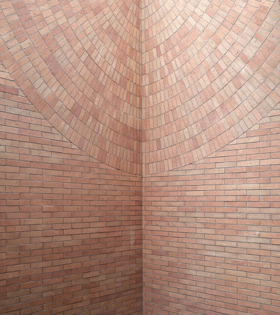 A textured brick wall featuring a circular pattern.