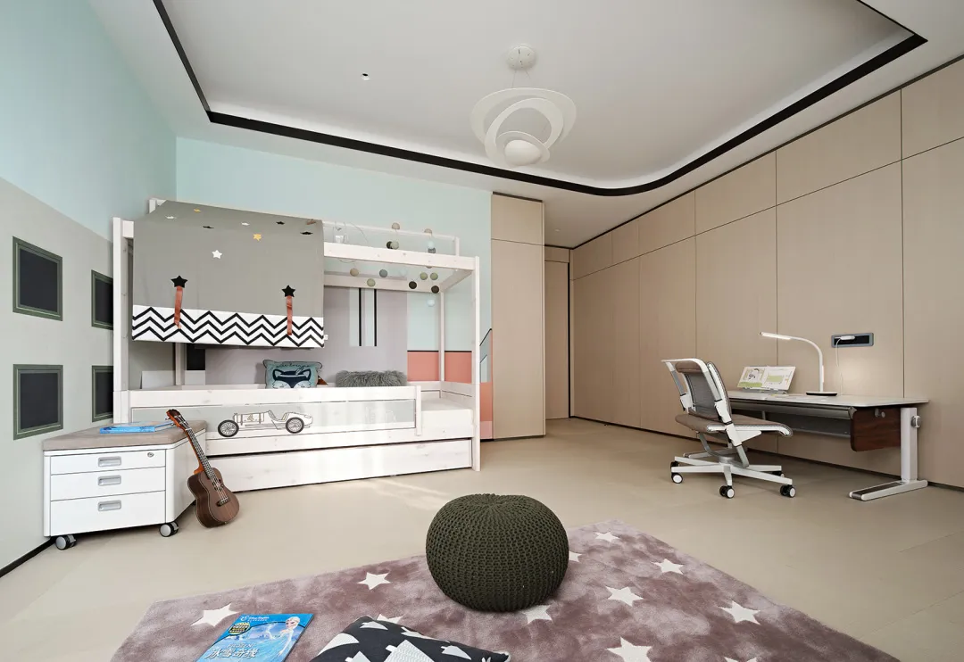 A modern child room with a white bunk bed, study area, and decorative elements.