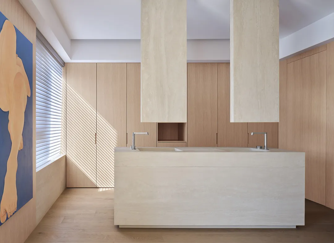 A modern kitchen with marble countertops and cabinets.