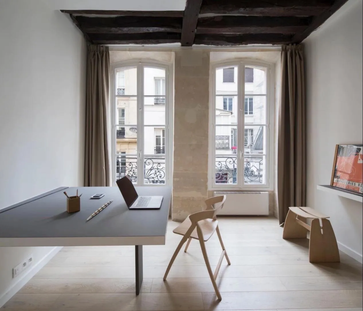 Modern minimalist living room with wooden furnishings and a sleek, gray table.