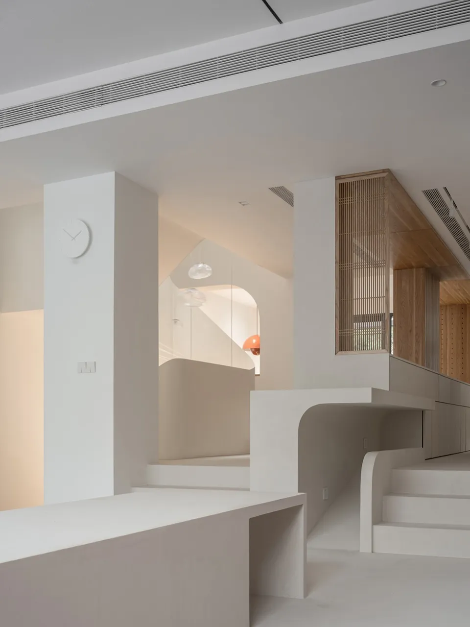A modern interior space with minimalist design, featuring exposed concrete walls and floors.
