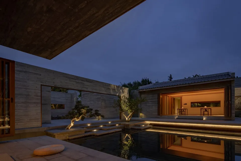 A modern residential exterior with concrete walls and glass elements.