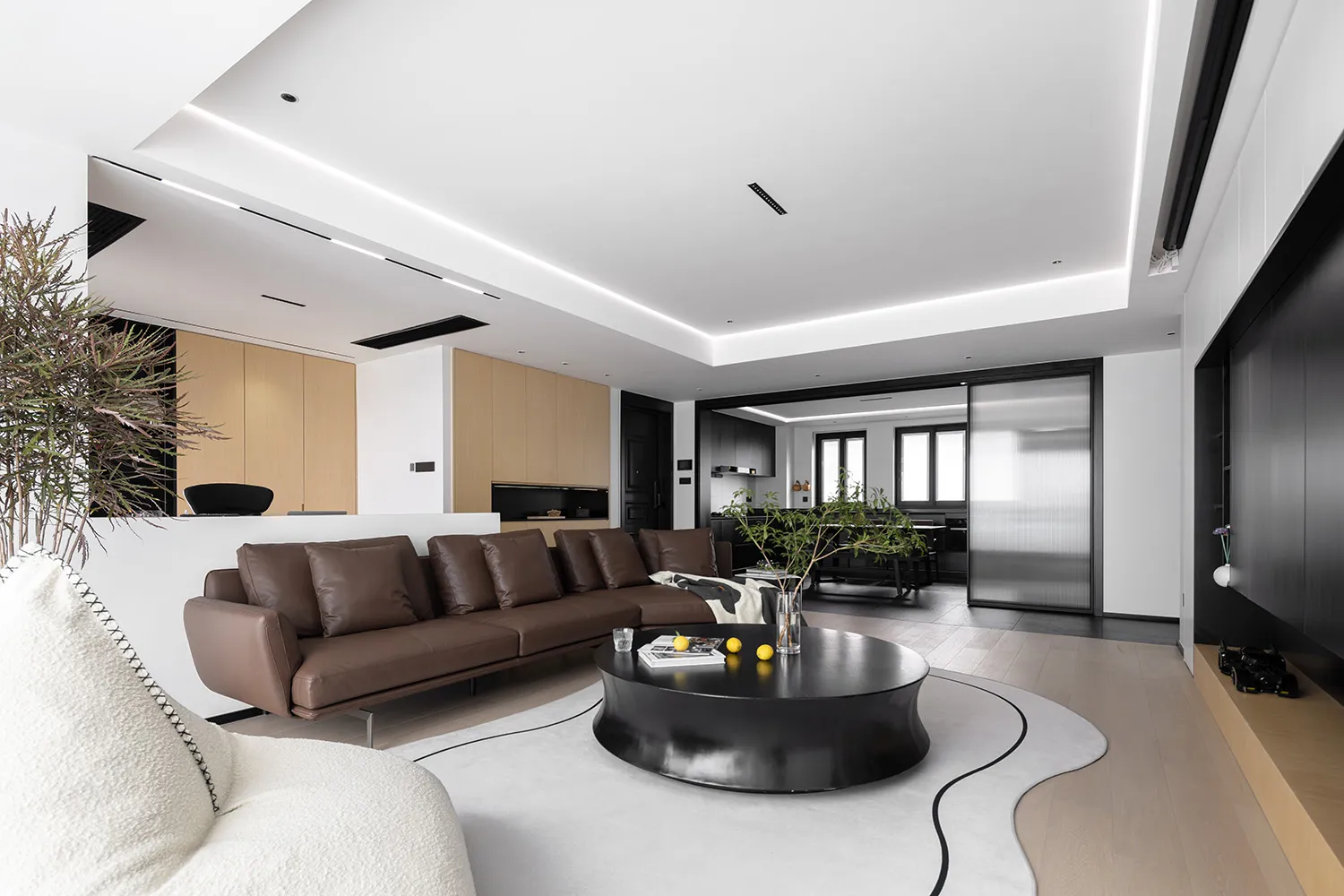Modern minimalist living room with a brown leather sectional sofa, white concrete flooring, and glass elements.