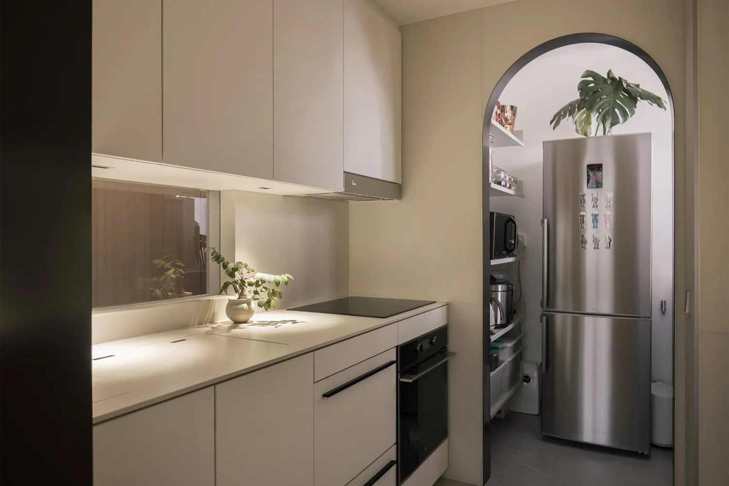 A modern kitchen with minimalist design and white cabinets.