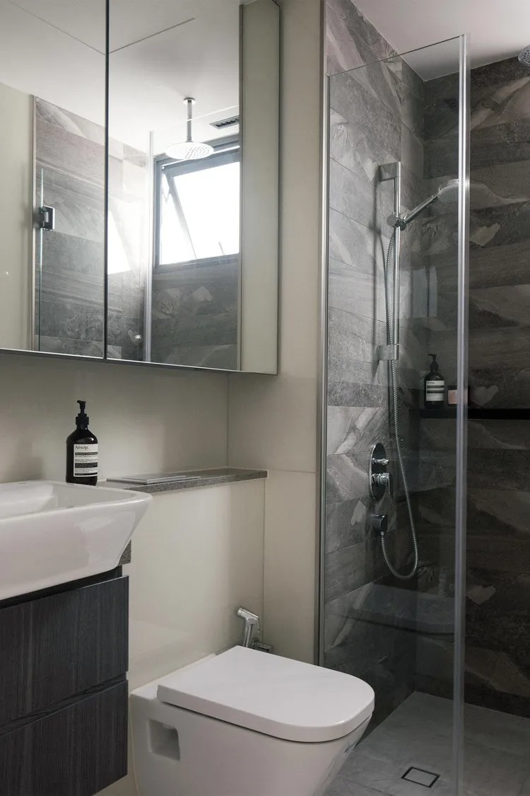Modern residential bathroom featuring gray marble tiles and a sleek, contemporary design.