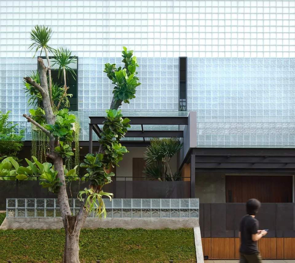 Greenery adorns the glass and wooden exterior of a modern building.