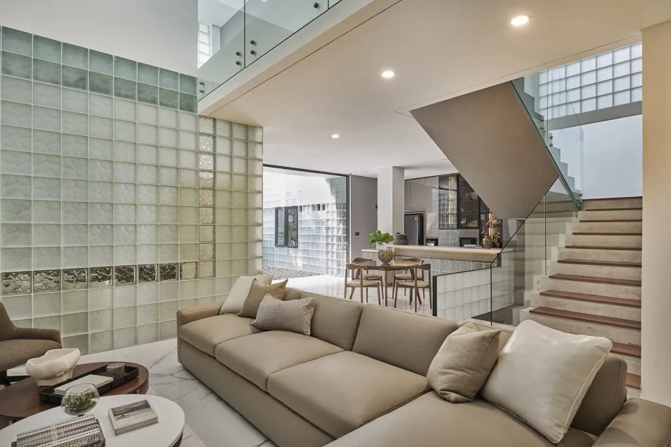 A modern living room with a glass wall and marble accents