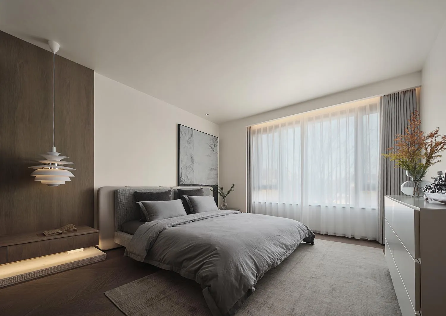 A minimalist bedroom with a gray fabric bed, white curtains, and a modern hanging light fixture.