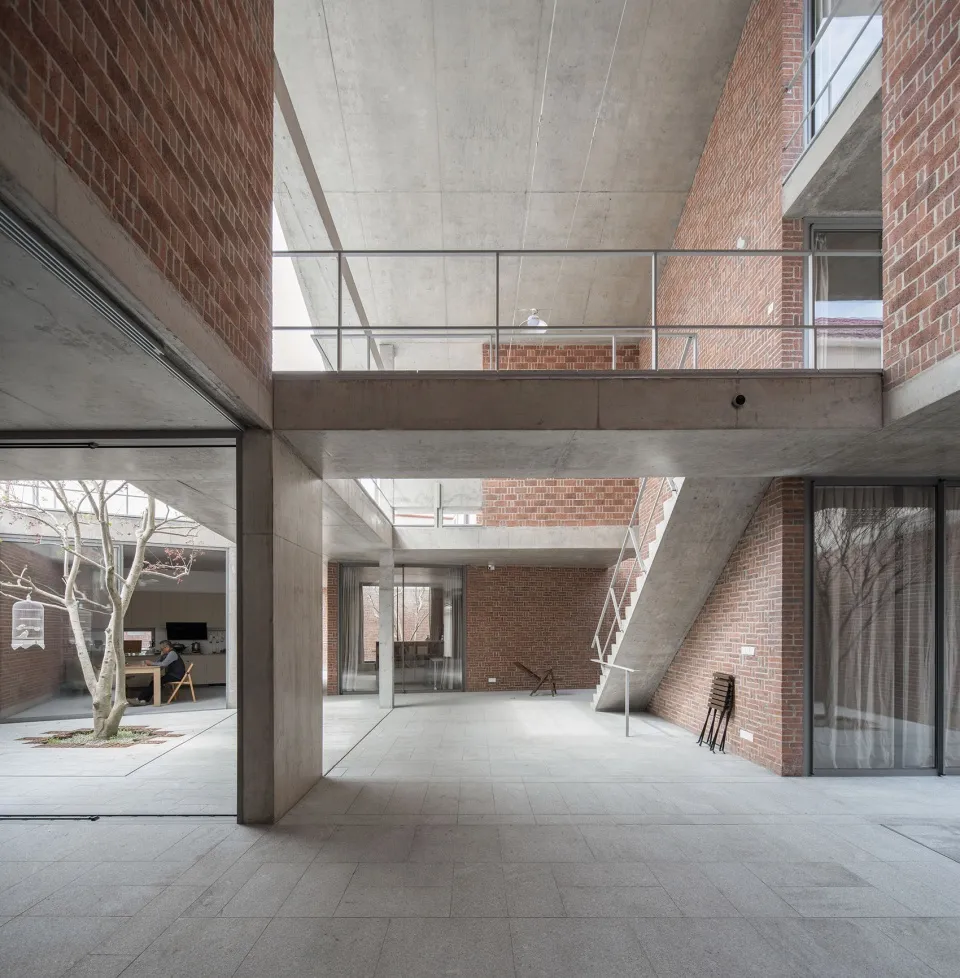 A modern office space with exposed brick walls and large windows.