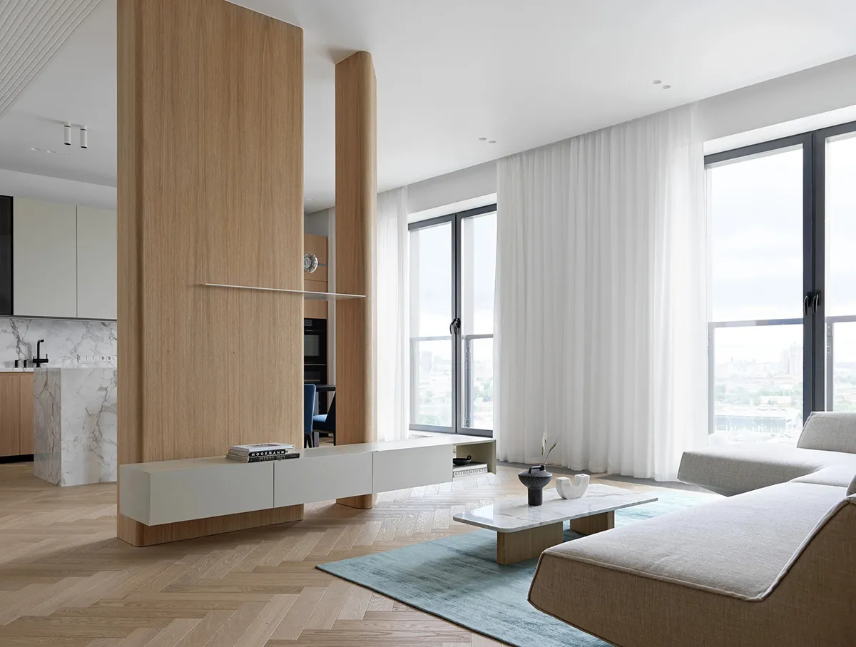 A modern minimalist living room with a marble coffee table, wooden floor, and large windows.