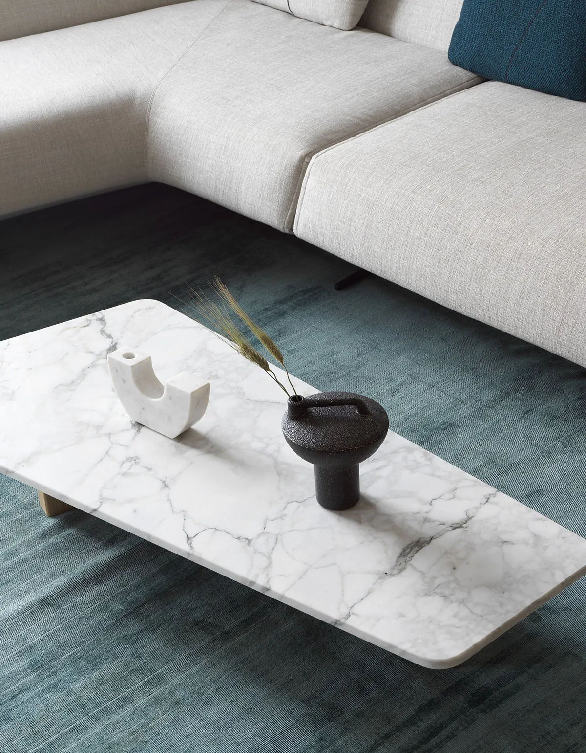 A modern marble living room with a white sofa and a marble coffee table.