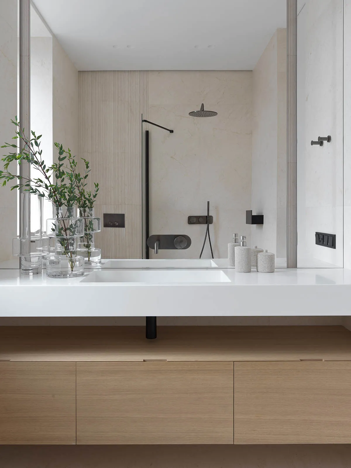 A minimalist modern bathroom with marble accents and sleek black fixtures.