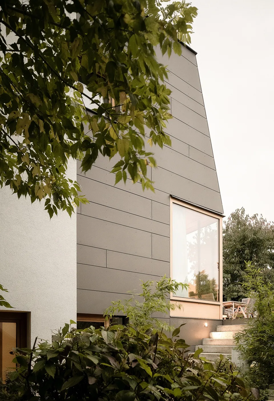 Modern minimalist house exterior with metal cladding and large windows