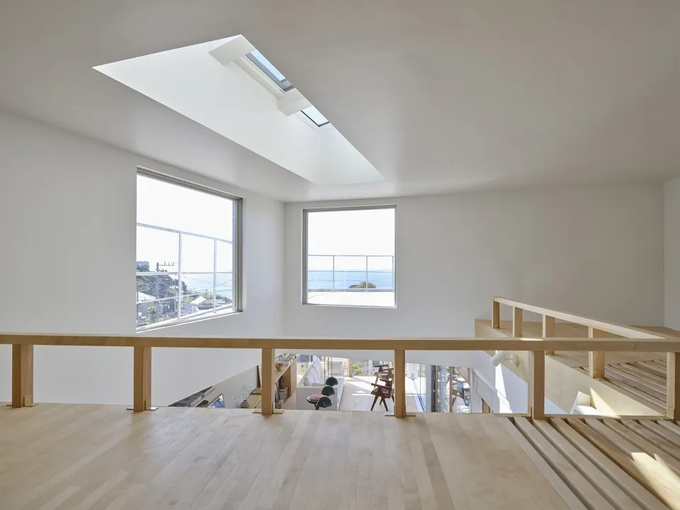 Minimalist living room with large windows, hardwood floors, and beams.