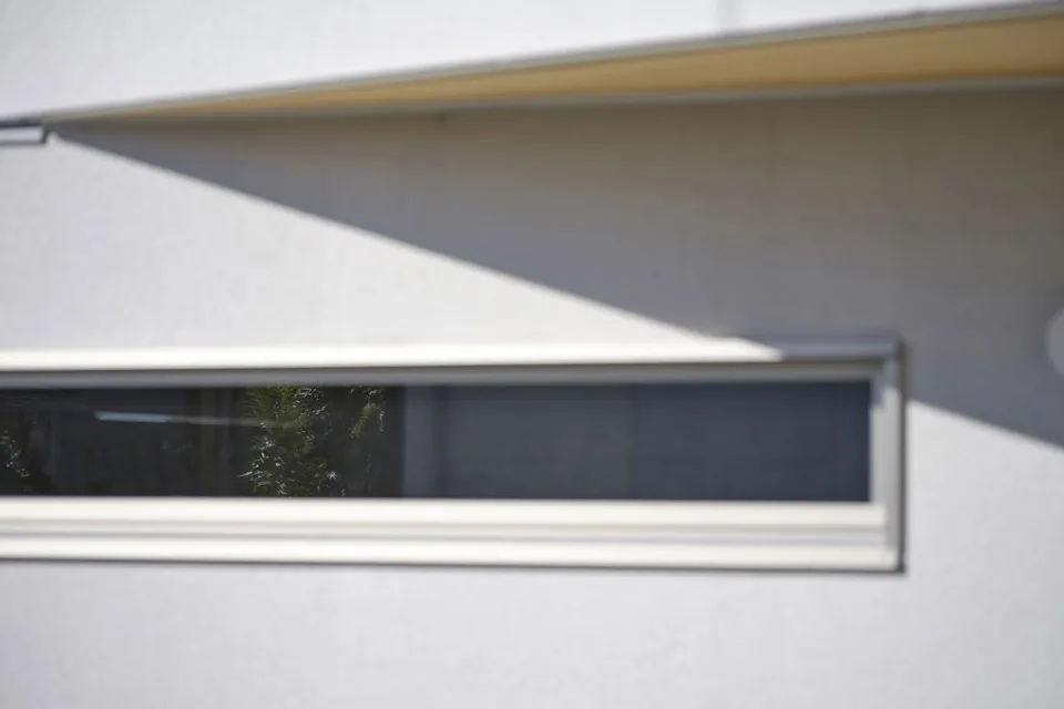 A modern house with a glass window reflecting outdoor scenery.