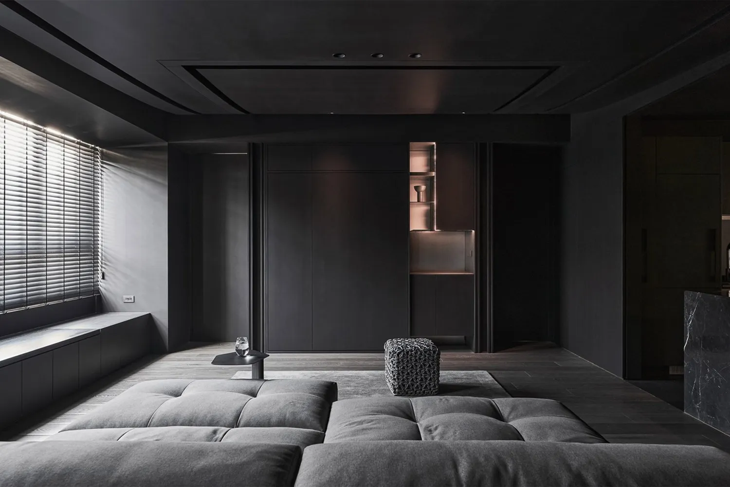 Modern minimalist living room with dark wood accents and leather seating, featuring dark metallic elements and a sleek, moder