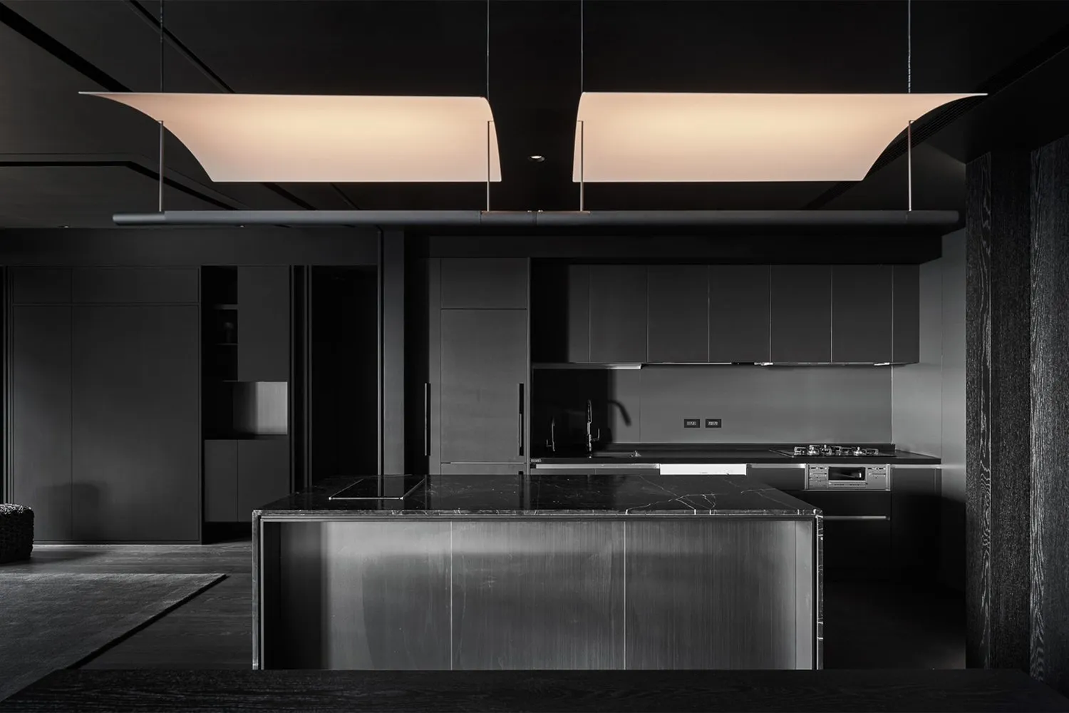 Modern kitchen with a minimalist design featuring marble countertops and stainless steel appliances.