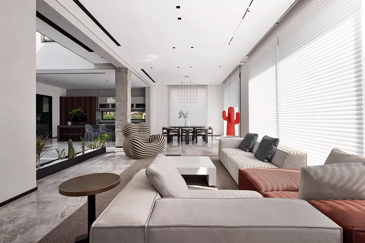 A modern living room with concrete and marble floors, large windows, and contemporary furniture, including a large white sofa