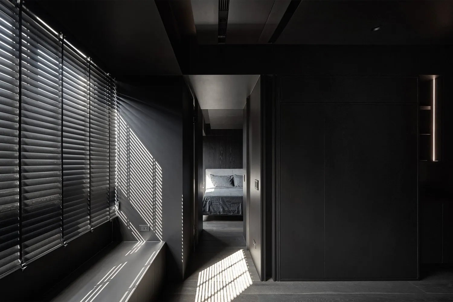 A modern minimalist bedroom with black and grey metal finishes.