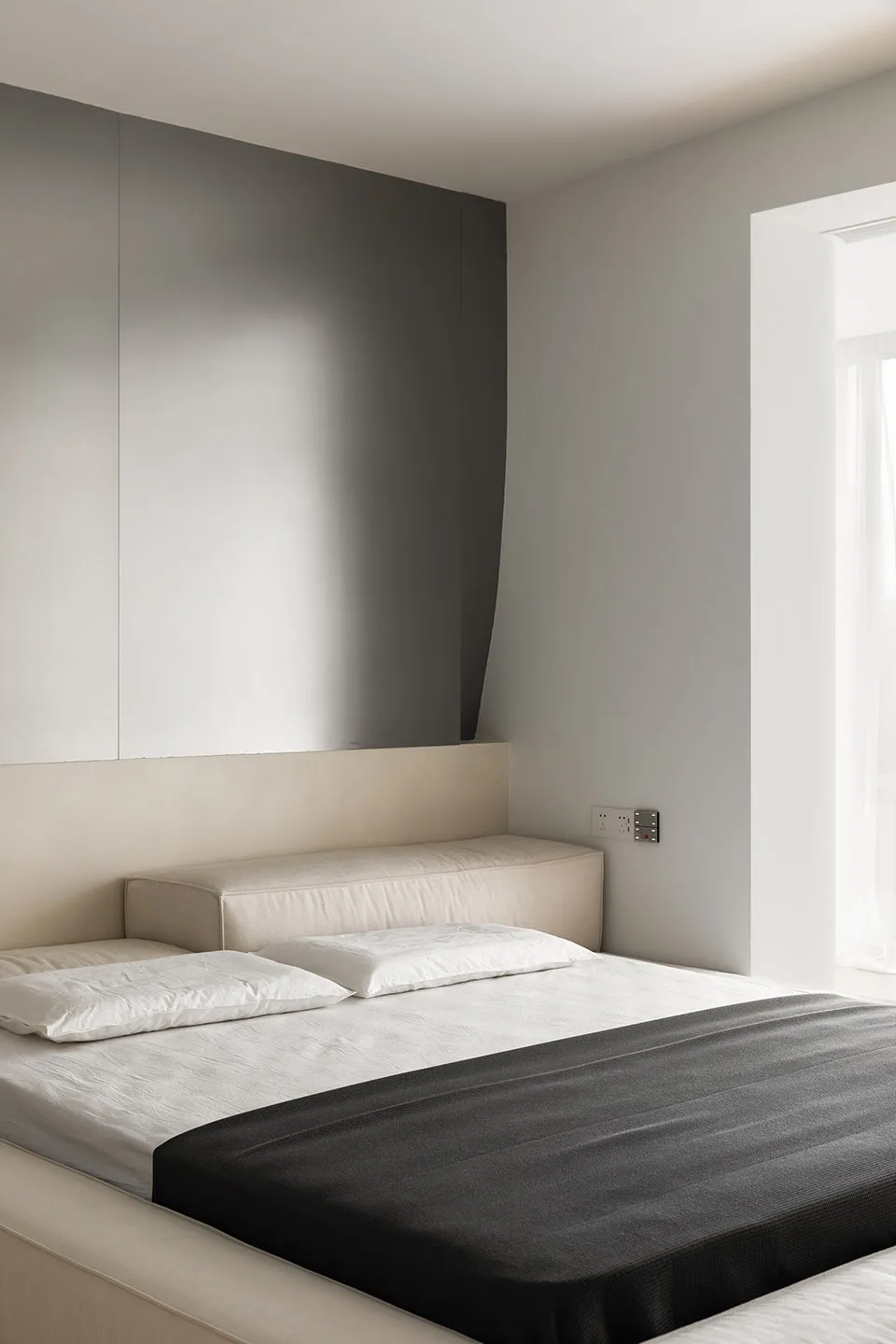 Modern minimalist bedroom with neutral color palette and simple design elements.