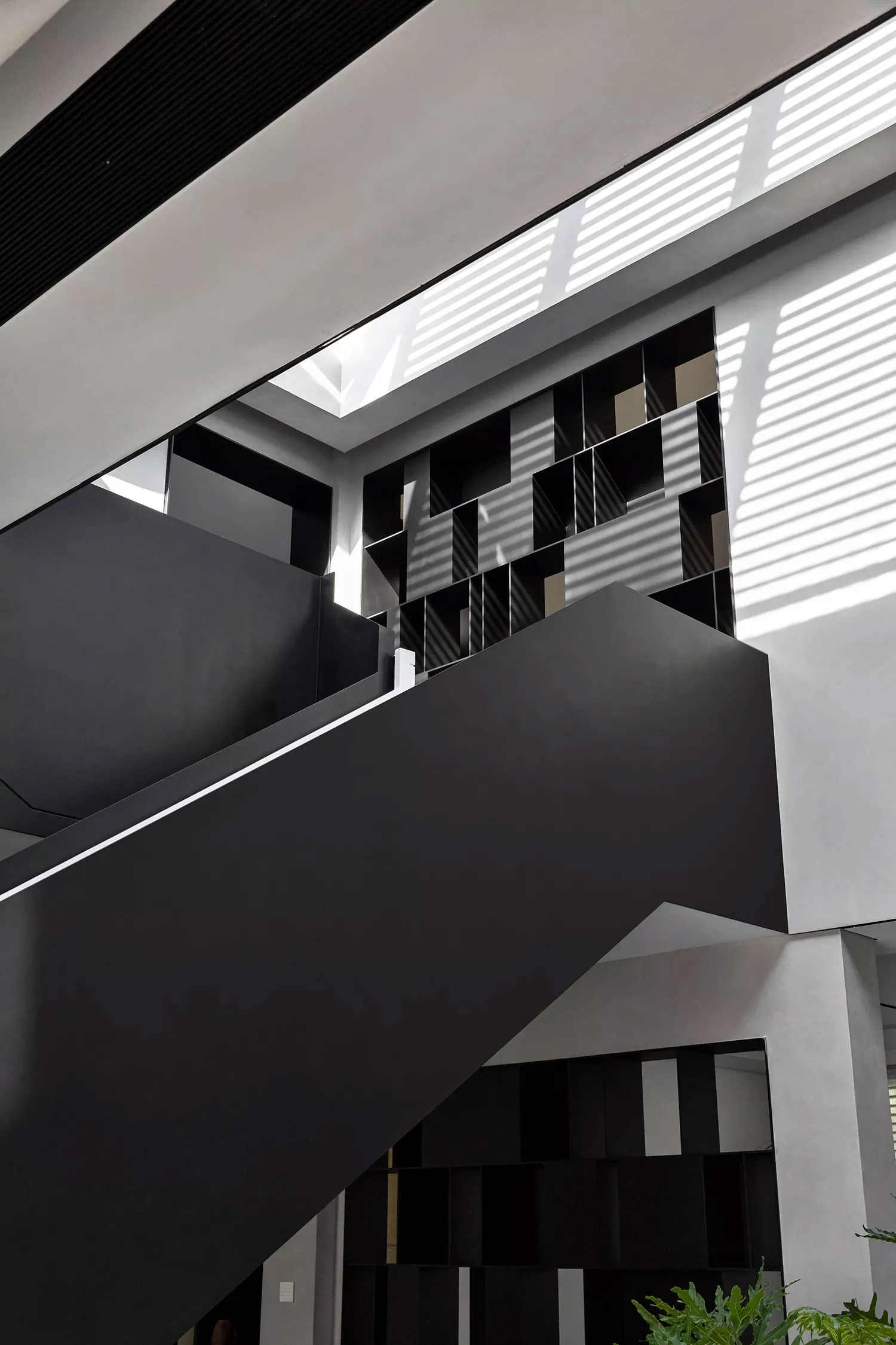 Modern interior design featuring matte black stairs and geometric concrete wall