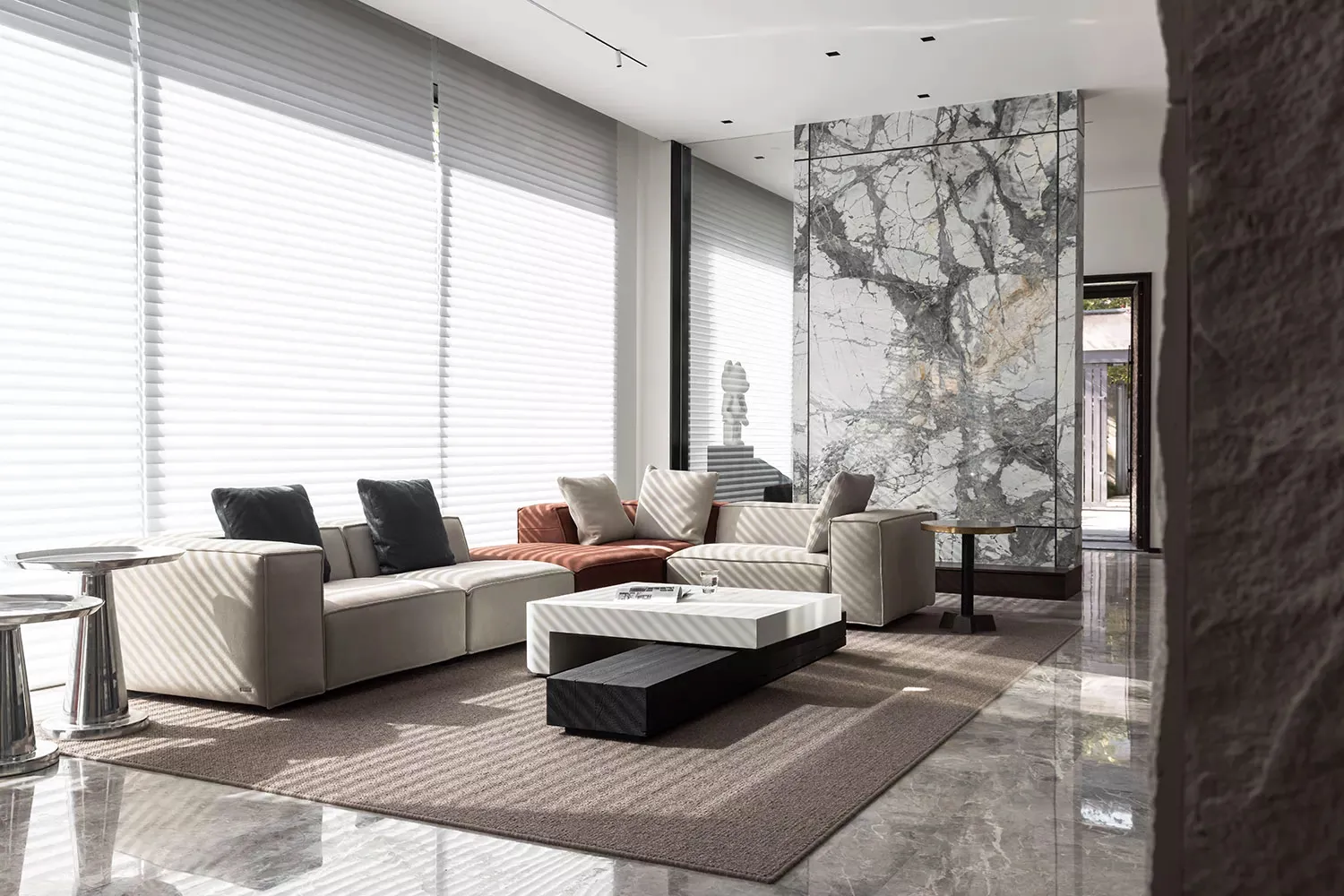 A modern living room with marble accents and leather furniture.