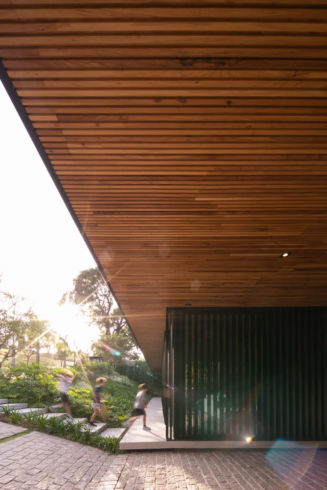 一座現代建築採用木質外觀,搭配斜屋頂與花園區域。
