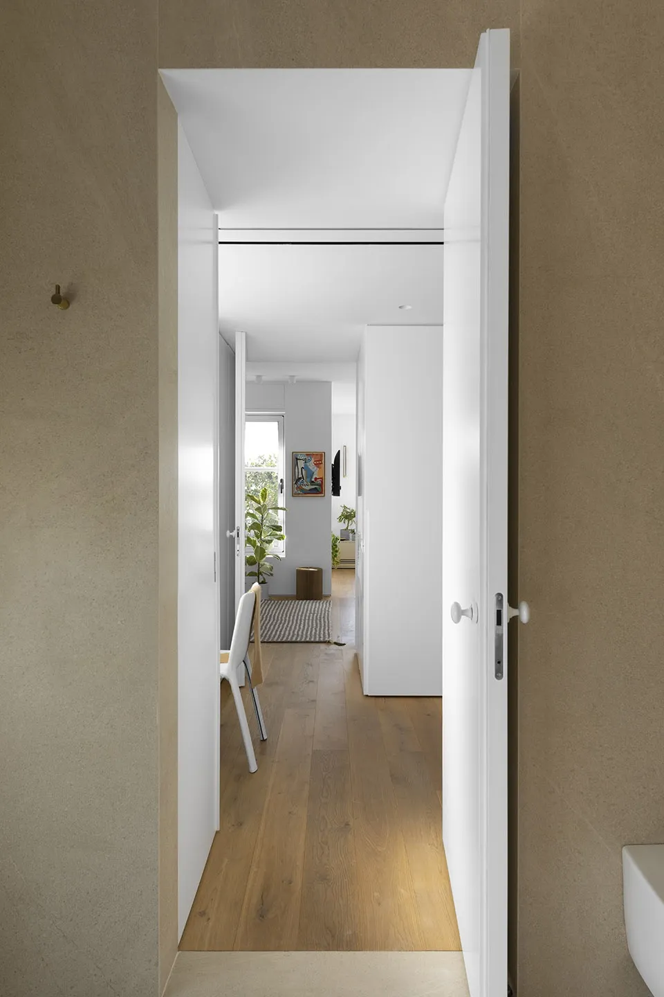 Minimalist room with neutral walls, wooden floor, and simple furniture.