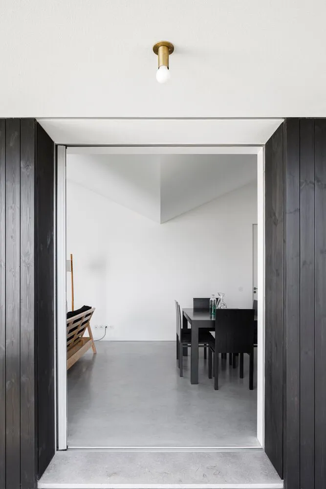Modern, interior design featuring a room with concrete flooring and minimalist furniture.