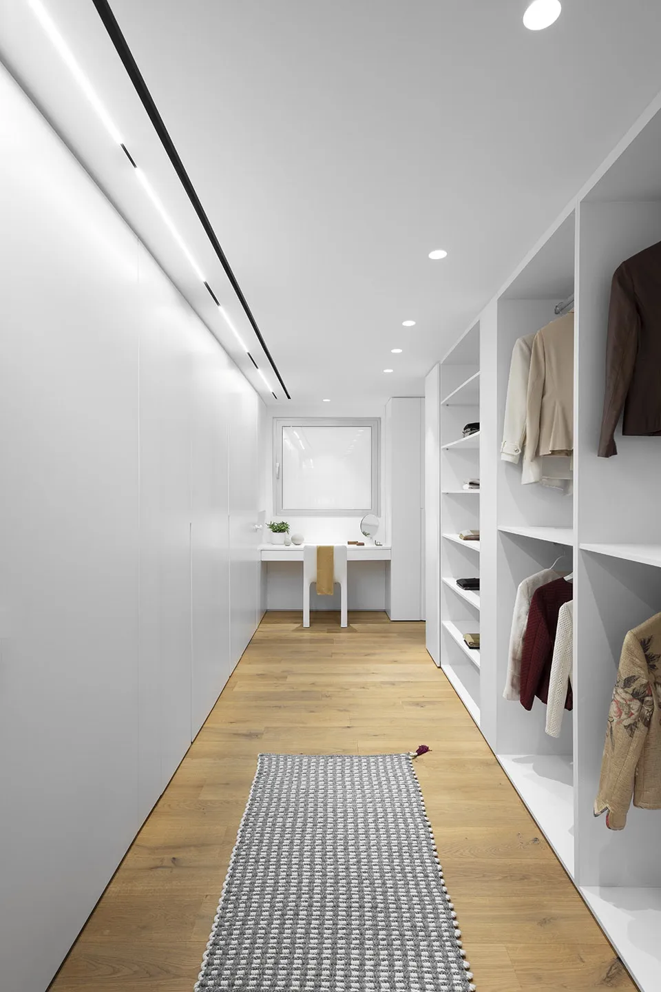 Modern minimalist closet with white materials and clothing storage