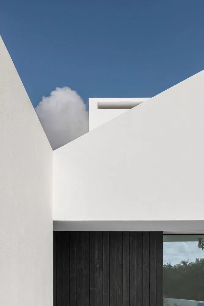 A modern building with a white exterior and concrete materials.