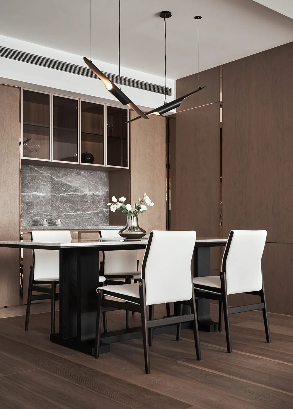 Modern minimalist dining room with white furniture and minimalist lighting fixtures.