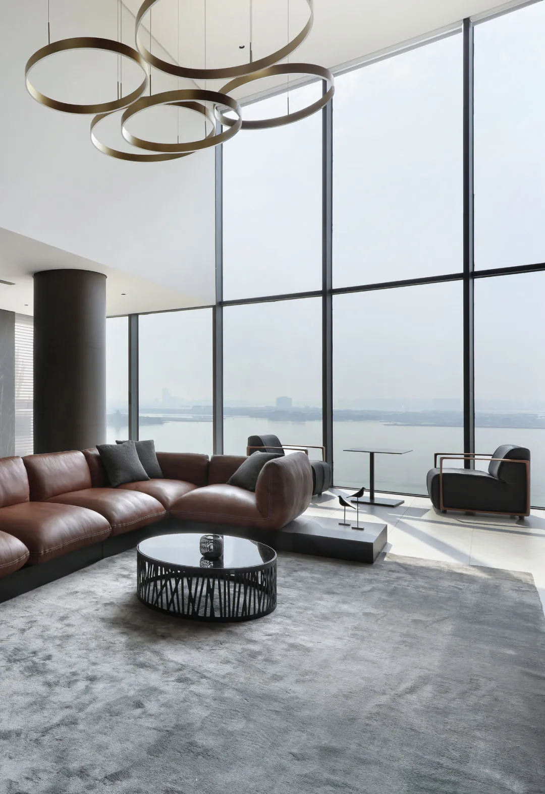 A modern living room with floor-to-ceiling windows overlooking a cityscape.