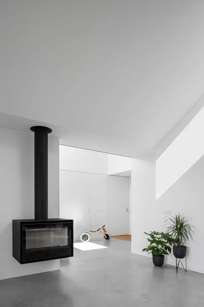 A minimalist interior design featuring concrete elements and a hanging fireplace.