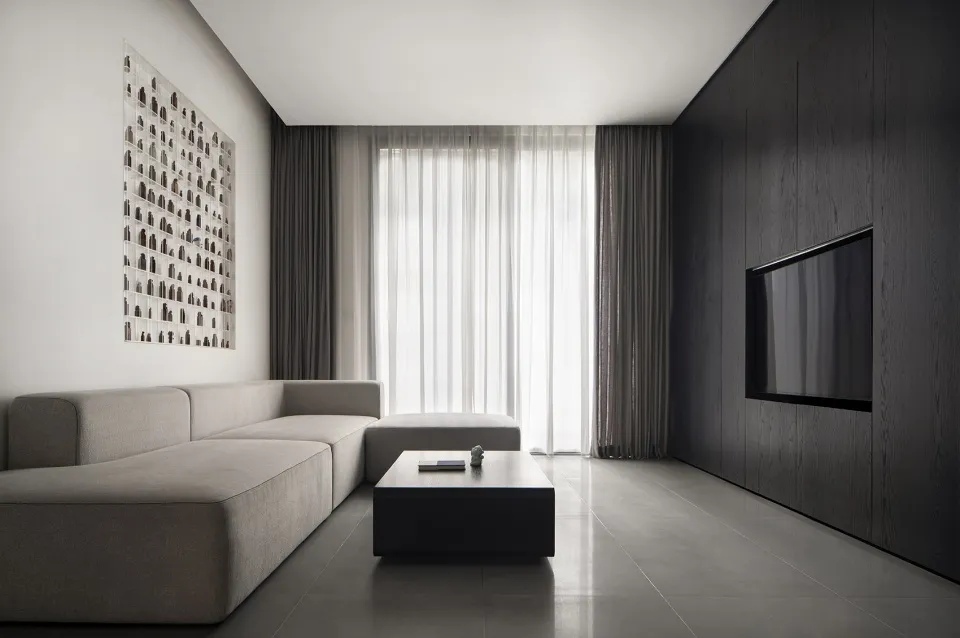 Modern minimalist living room featuring metallic accents, glass windows, and upholstered furniture.