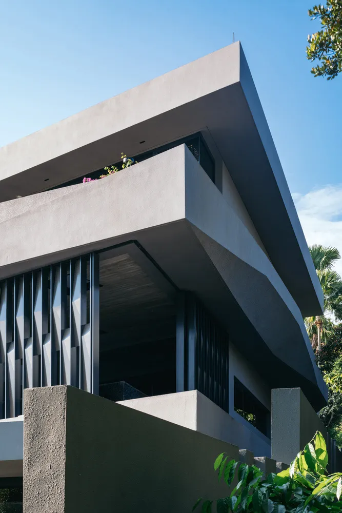 Exterior view of a modern residential building featuring a concrete façade and angular architectural design.