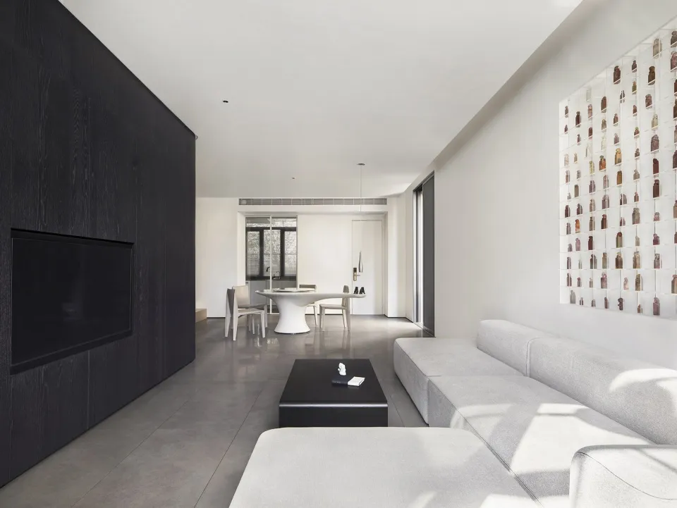 A minimalist living room with a concrete floor and leather sofa.