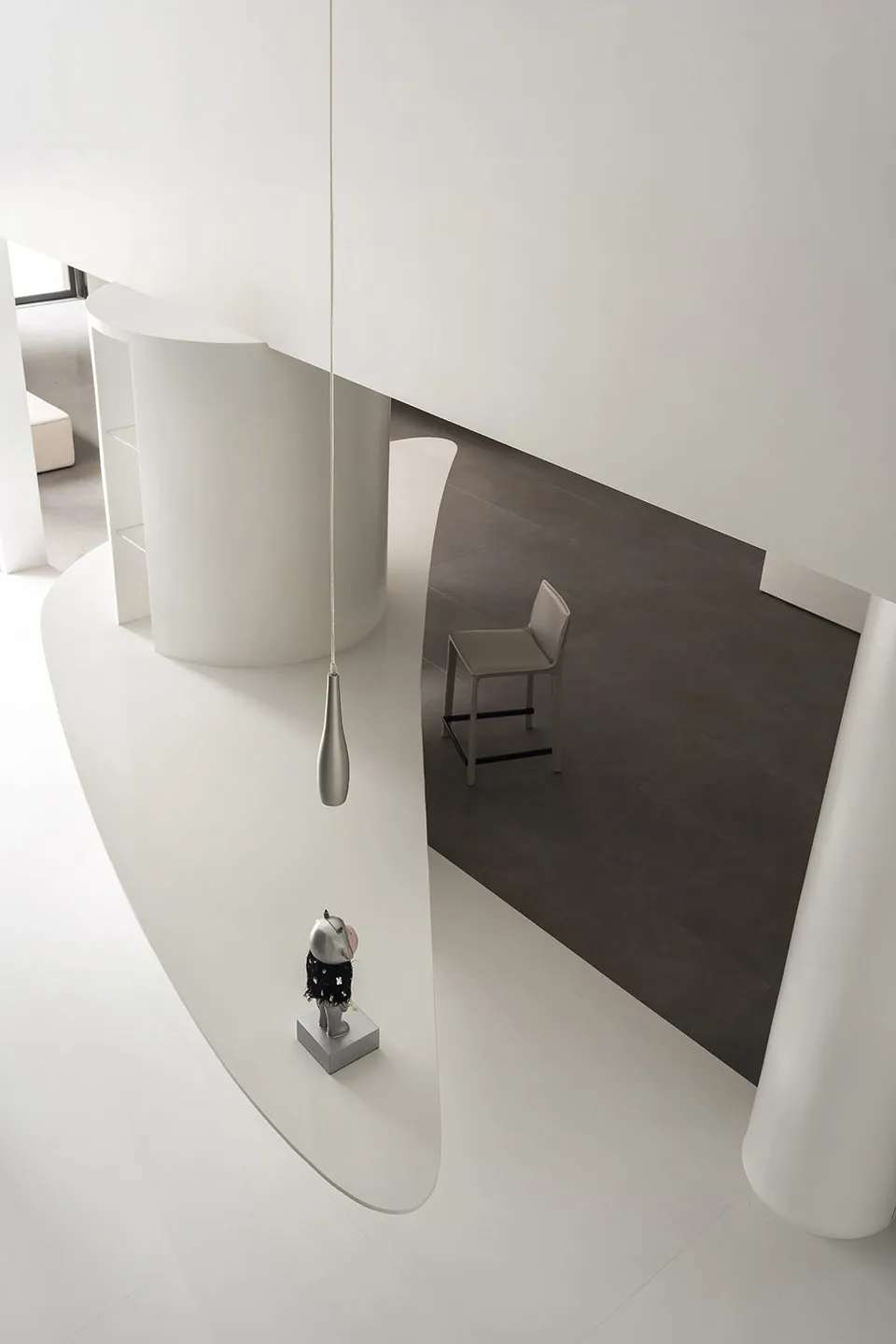 A minimalist modern interior design featuring clean white concrete surfaces and sleek stainless steel elements.