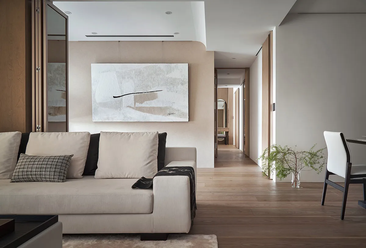Modern living room with neutral-colored furniture and abstract artwork on the wall.