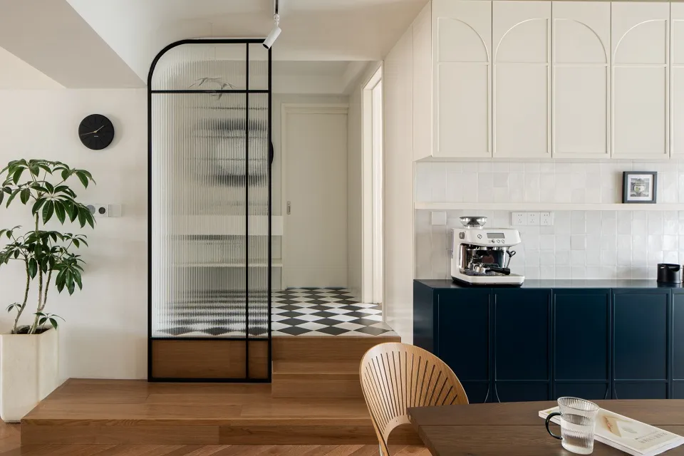 A minimalist kitchen featuring wooden cabinets, glass doors, and metallic fixtures.