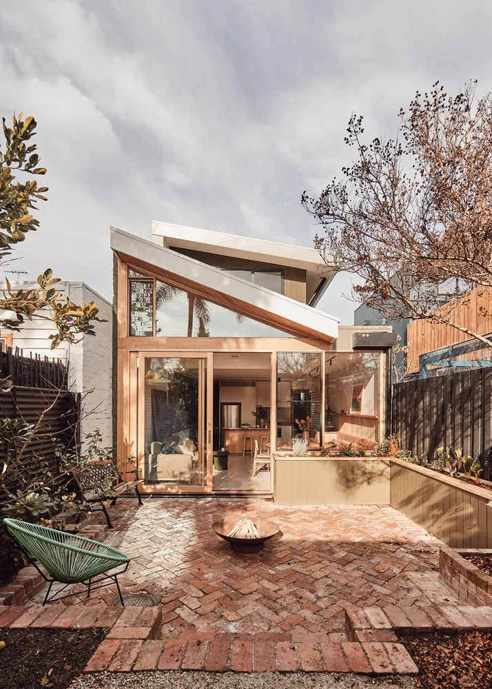 Modern exterior view of a home featuring brick, glass, and motion elements.