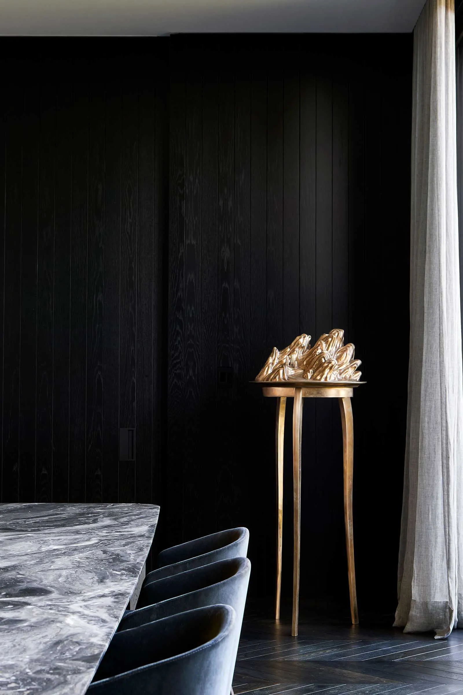 Modern dining room with marble table and metallic centerpiece.