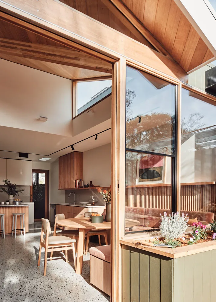 Modern kitchen dining room with wood accents and glass windows.