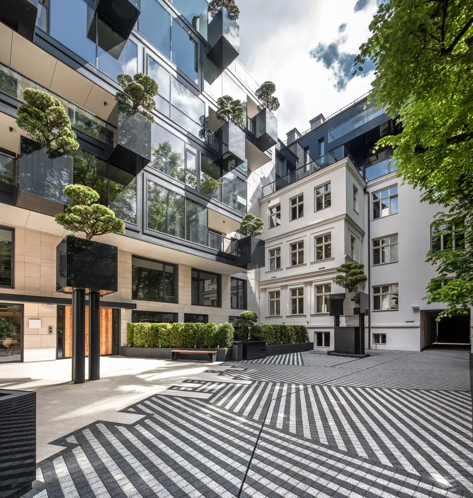 A modern commercial space with a glass facade and geometric courtyard.