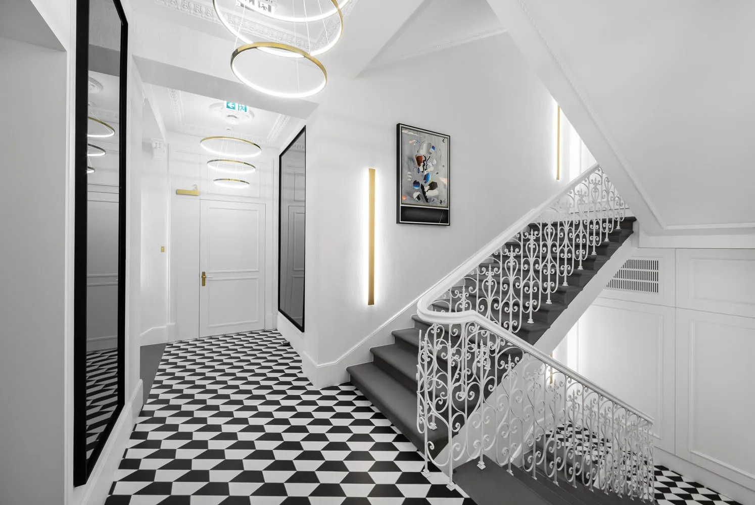 A modern hallway with black and white patterned floor, white walls, and a metal wire railing.