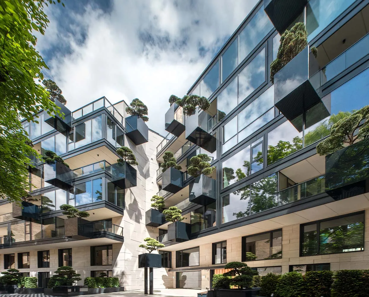 Modern high-rise building with glass windows and greenery
