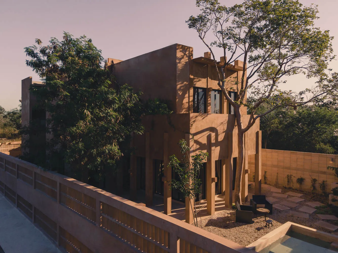 Modern residential house made of sandstone with a courtyard and trees.