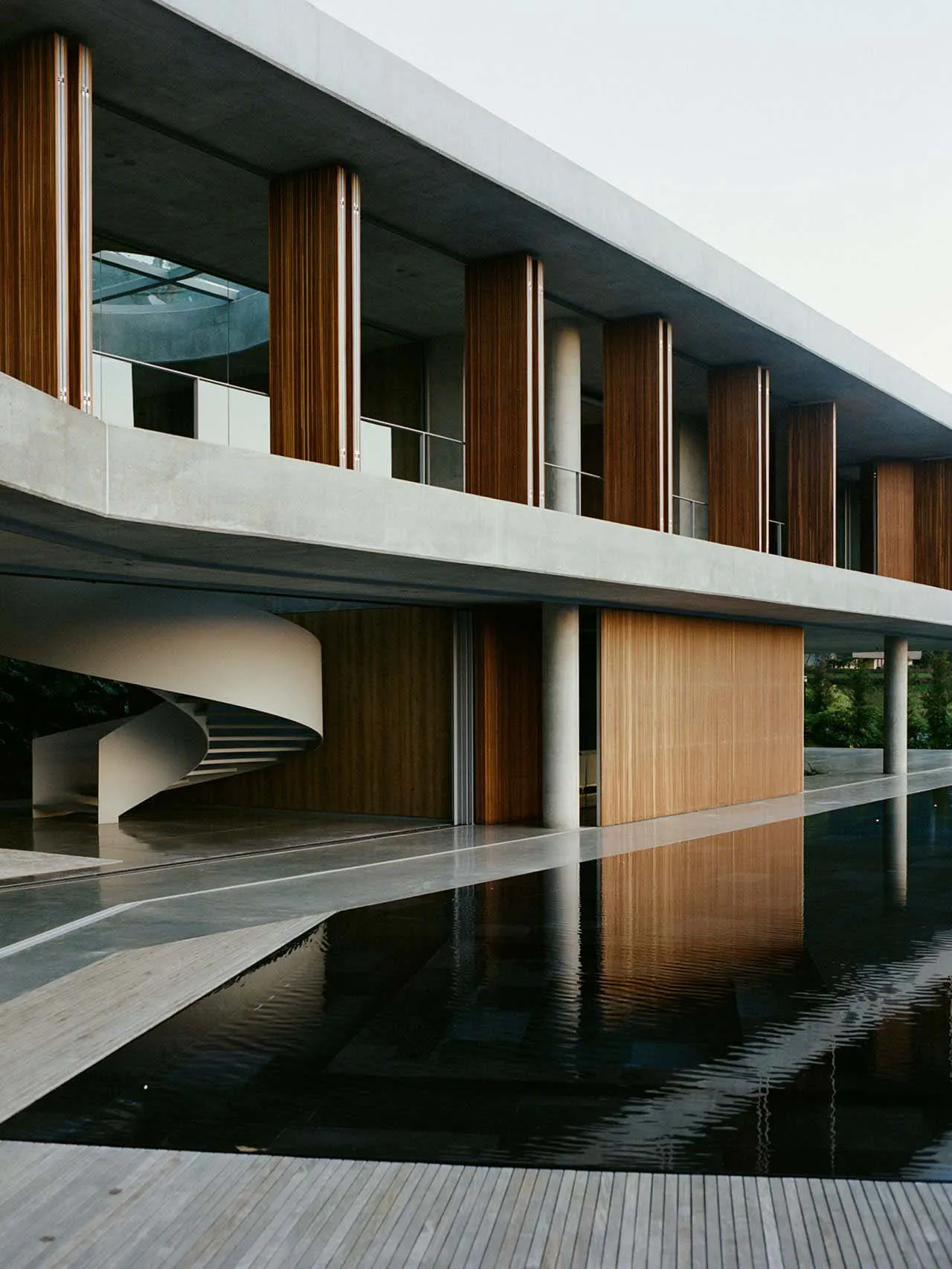 A modern building with concrete, glass, and wooden elements.