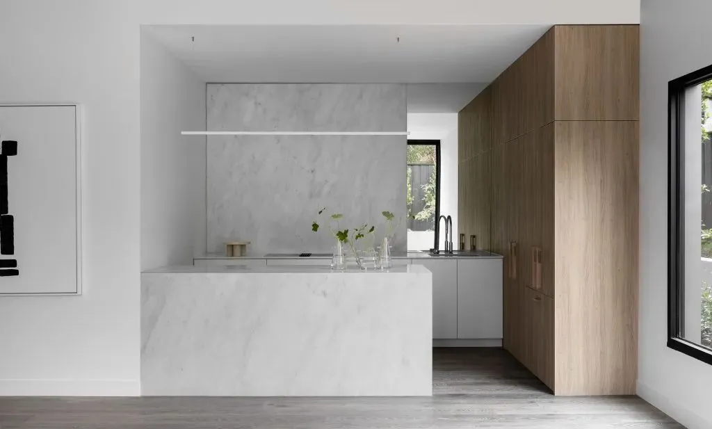Modern kitchen featuring white marble countertops and minimalist design.