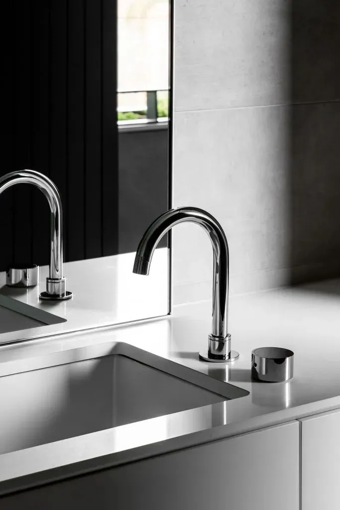 Modern kitchen with a sleek, metallic sink and minimalist design.